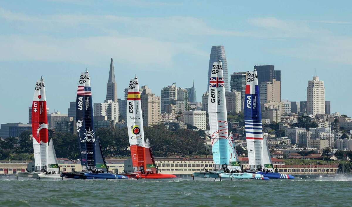 The F50 catamaran fleet crosses the start line in the first SailGP race in San Francisco Bay.