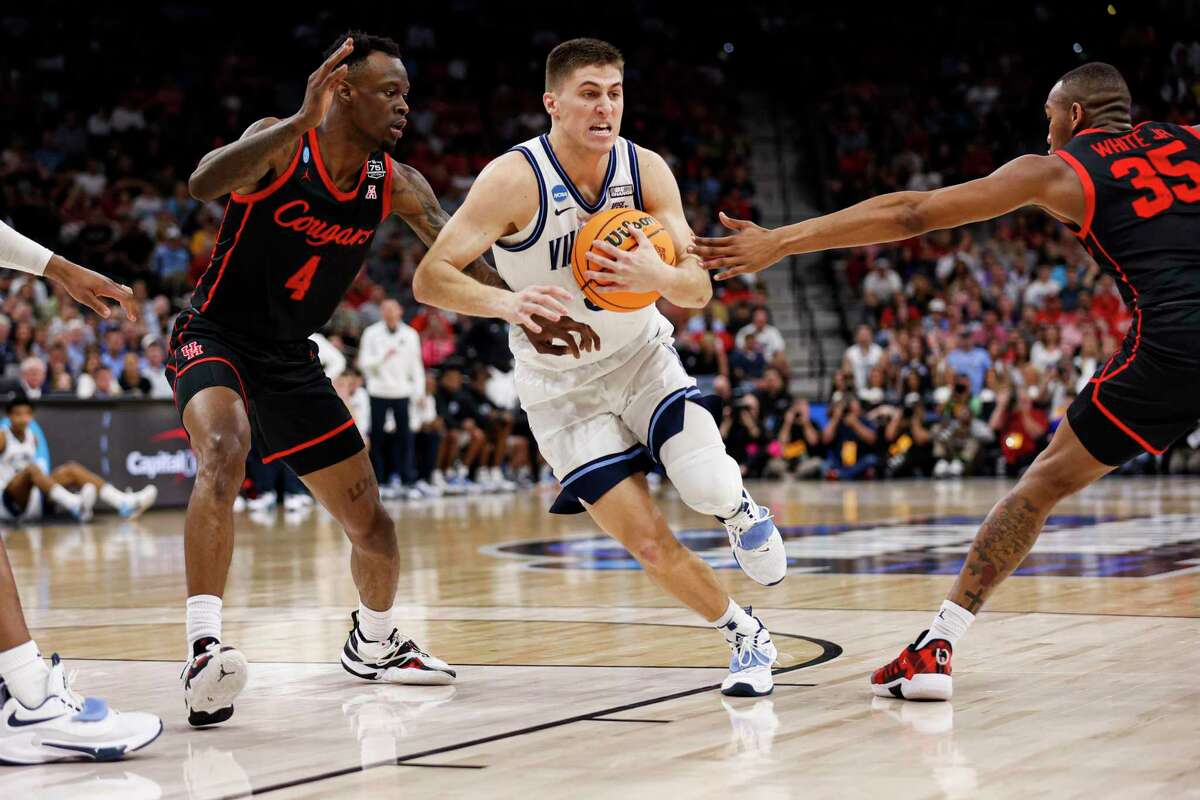 Villanova Wildcats guard Collin Gillespie (2) drives through Houston Cougars guard Taze Moore (4) and forward Fabian White Jr. (35) during the first half of the NCAA South Regional men’s basketball final at AT&T Center, Saturday, March 26, 2022, in San Antonio, Texas.