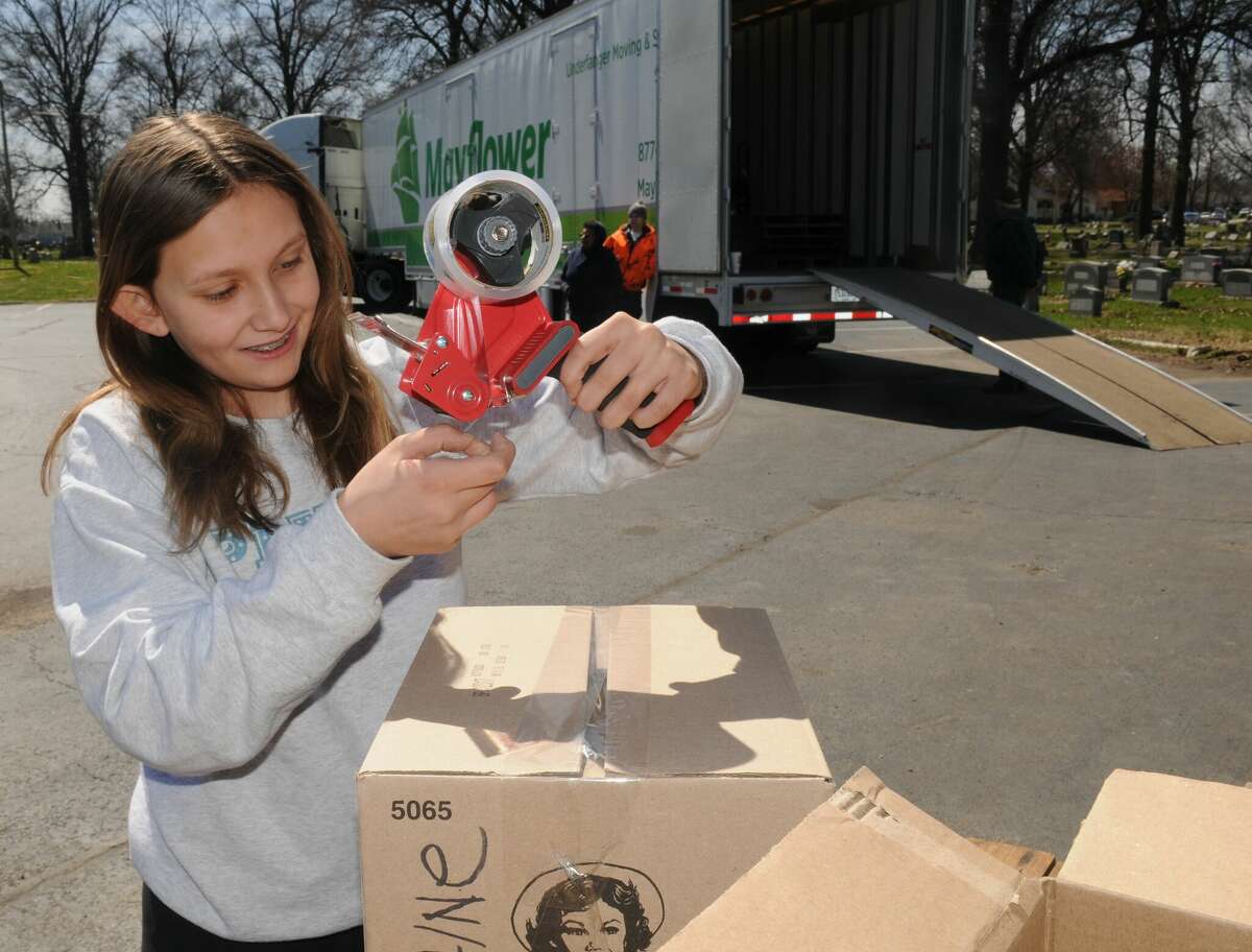 Twelve-year-old Ava Relleka helps to pack boxes during the "Send a Semi to Ukraine" drive over the weekend in Granite City.