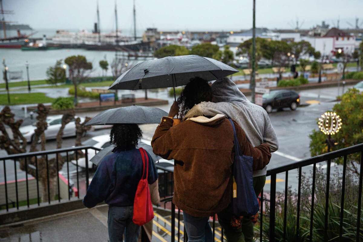 People pass by Ghirardelli Square in San Francisco. After a dry, sunny Saturday, the Bay Area transitions into a wet weather on Sunday night, March 27, 2022.