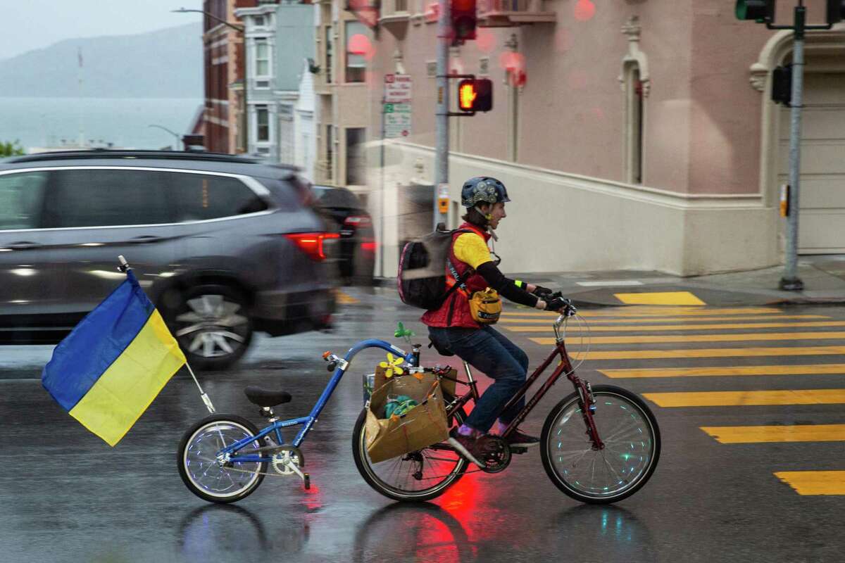 A woman rides bike on North Point Street in San Francisco. After a dry, sunny Saturday, the Bay Area transitions into a wet weather on Sunday night, March 27, 2022.