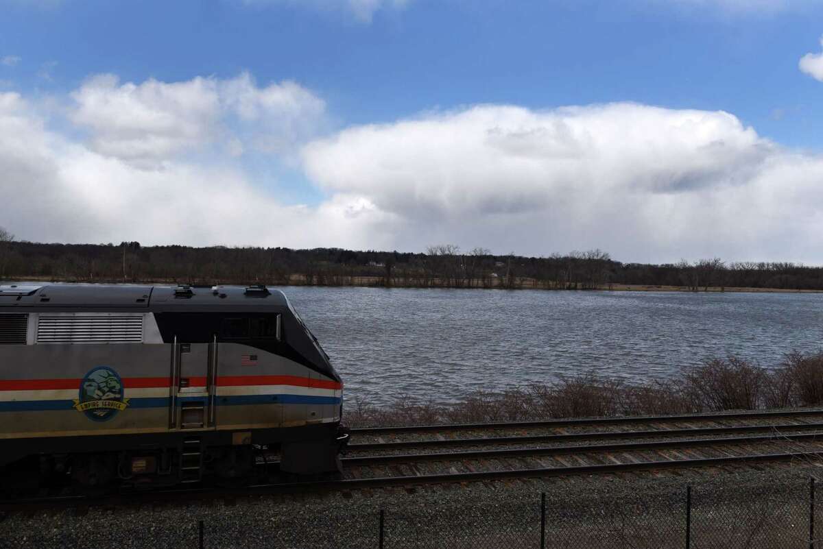 An Amtrak trains heads north along the Hudson River on Monday, March 28, 2022, in Castleton, N.Y.
