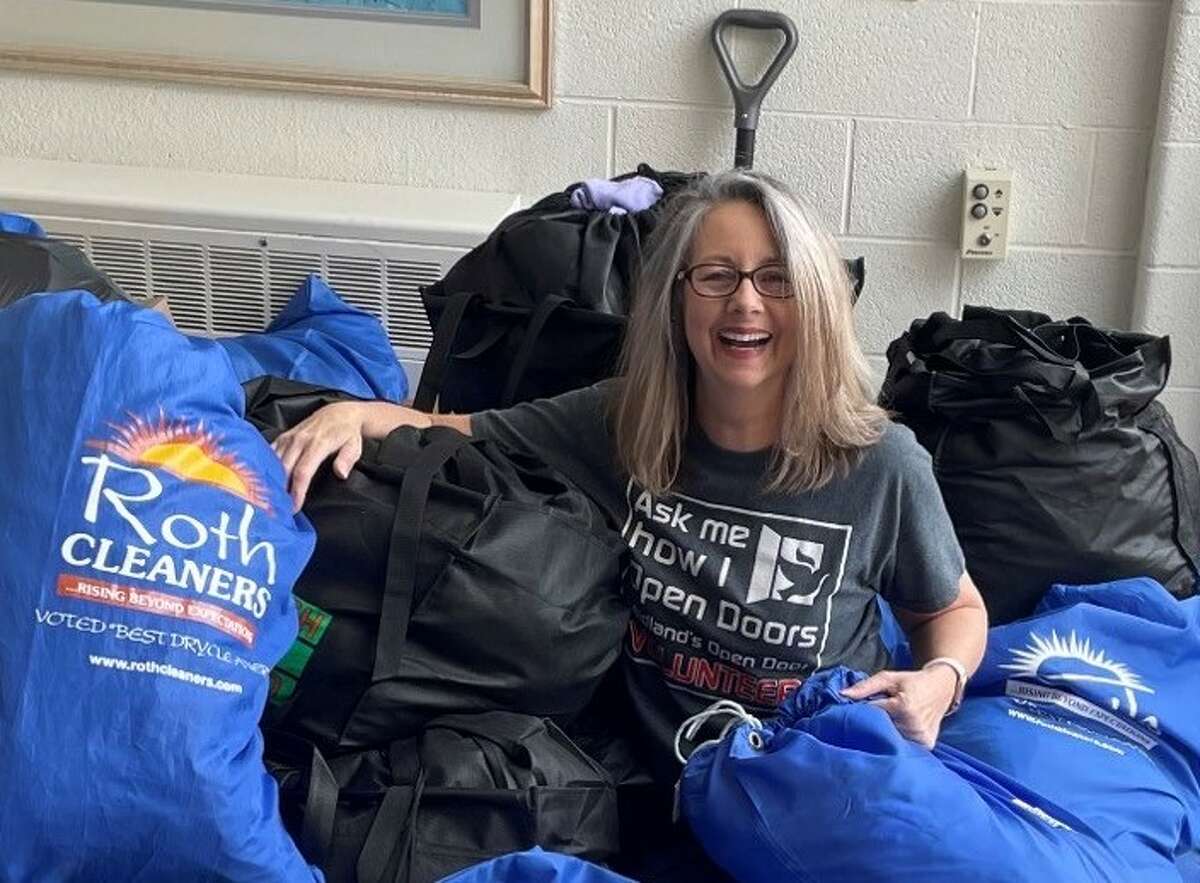 Open Door's Volunteer Clothing Ministry Coordinator Janine Bensch poses with donations of warm clothes for God's Country Cooperative Parish.