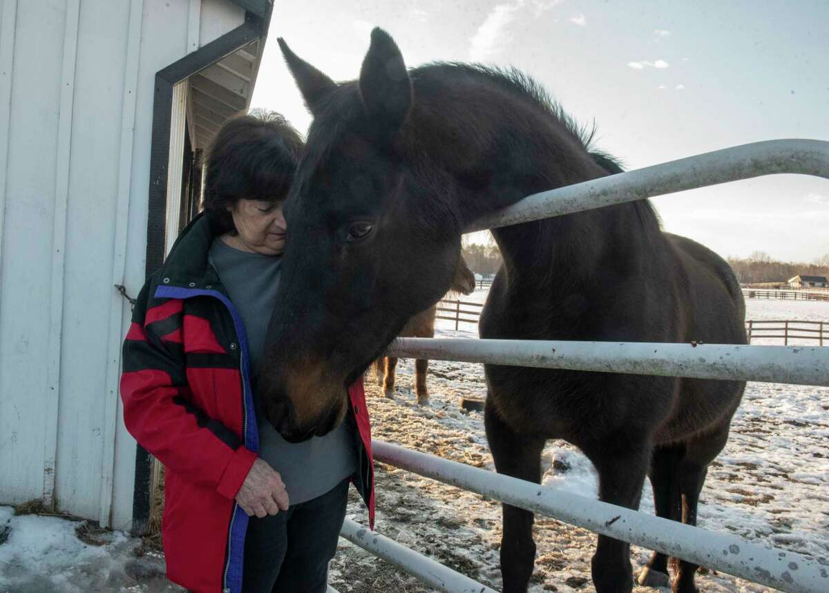 Susan Wagner, founder and president, is seen with retired thoroughbred Rose at her rescued horses facility Equine Advocates on Wednesday, March 2, 2022 in Valatie, N.Y.
