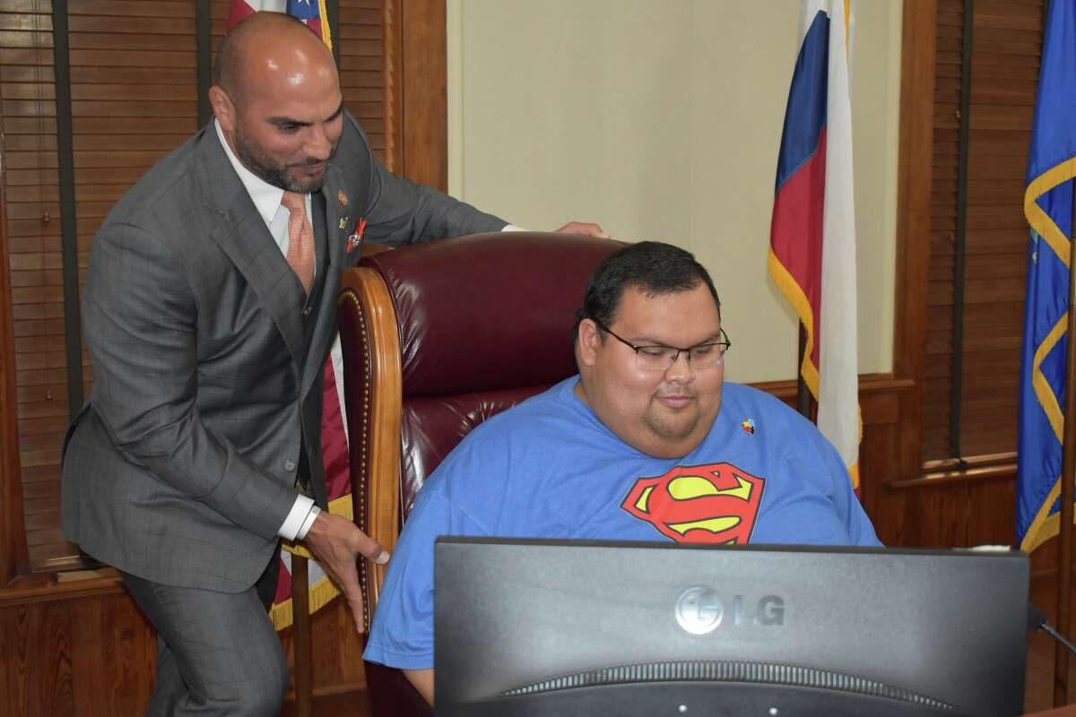 Tito Orduno is offered a seat by County Judge Tano Tijerina during the Monday Commissioner Court Meeting that proclaimed April 2022 Autism Awareness Month.