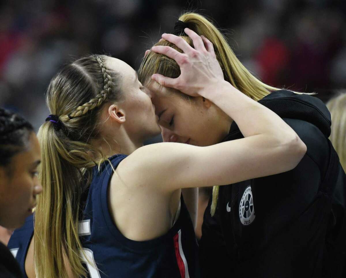 UConn’s Paige Bueckers, left, kisses teammate Dorka Juhasz on the forehead after Juhasz was injured in the Huskies’ double-overtime win against NC State in an Elite Eight game March 28. “She’s always there for us,” Juhasz said, “and even at those moments, she came to me, she gave me a kiss on the forehead and said that she’s doing this for me, to go out there and score so many points and won that game.”