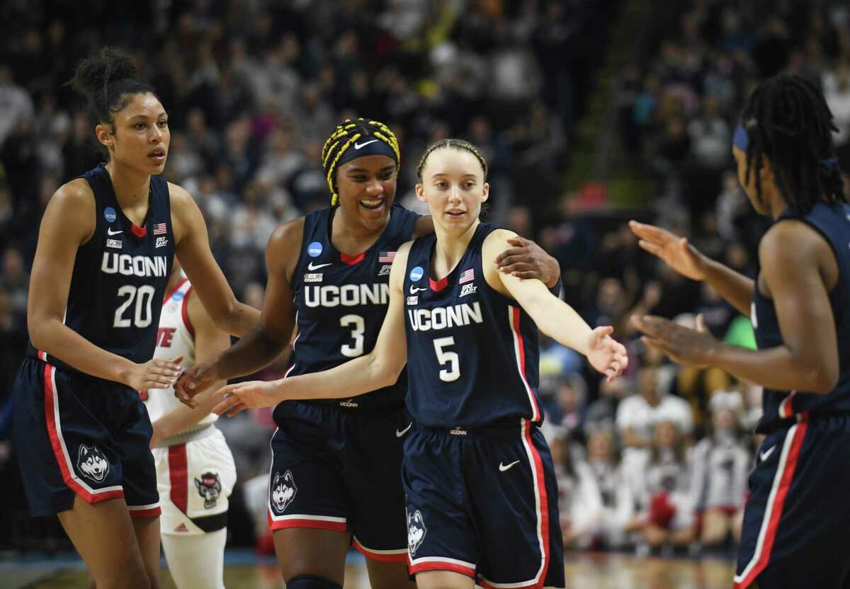 UConn's Olivia Nelson-Ododa (20), Aaliyah Edwards (3), Paige Bueckers (5), and Christyn Williams (13) celebrate during No. 2 UConn's 91-87 double overtime win against No. 1 NC State in the NCAA women's basketball tournament Elite Eight matchup at Total Mortgage Arena in Bridgeport on Monday, March 28.