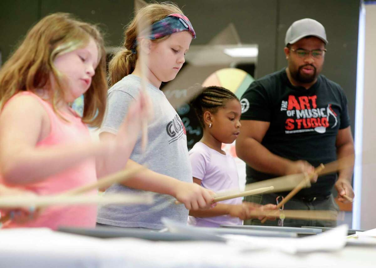 Jourdyn Mackey, second from right, works on her drumming of “This Land is Your Land” by Woody Guthrie during the Multi-Arts Camp at the Owens Theatre, Thursday, June 17, 2021, in Conroe. Area volunteers taught 21 students at the week-long camp the fundamentals of art, acting and music. Sign up for this year’s camp is open now.