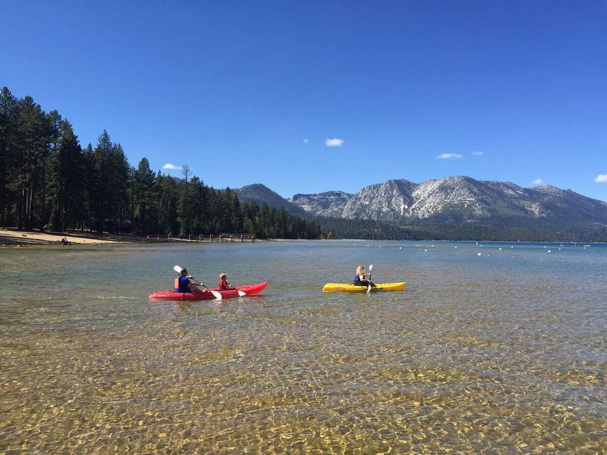 Kayakers paddle along the shores of Lake Tahoe at Camp Richardson Historic Resort & Marina.
