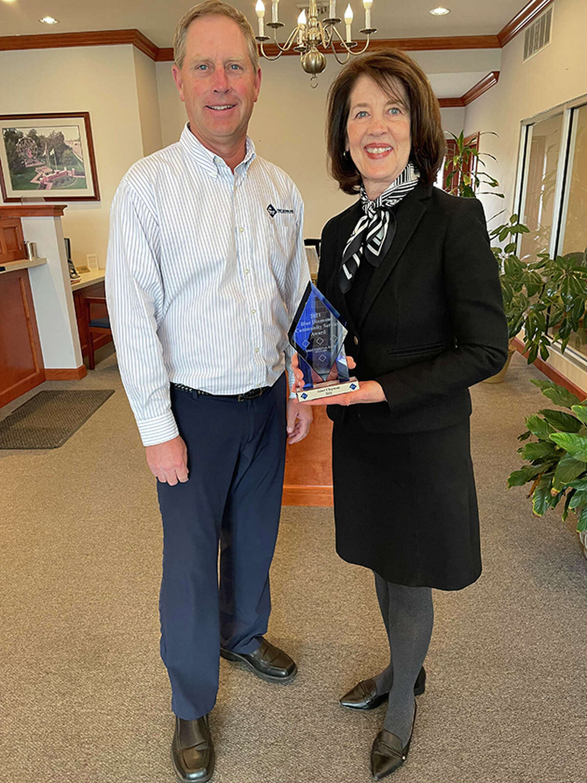 First National Bank of Arenzville President Kai Schnitker presents Janet Chipman of Jacksonville with the bank's Blue Diamond Community Award for 2021. 