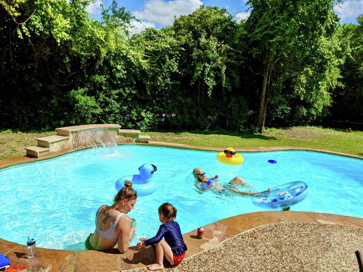 Amy and Torin Simpson, along with a friend's young daughter, relax in the pool they recently rented on the Swimply sharing platform. Amy estimated that since last March they have rented three different pools in and around San Antonio a total of eight times.
