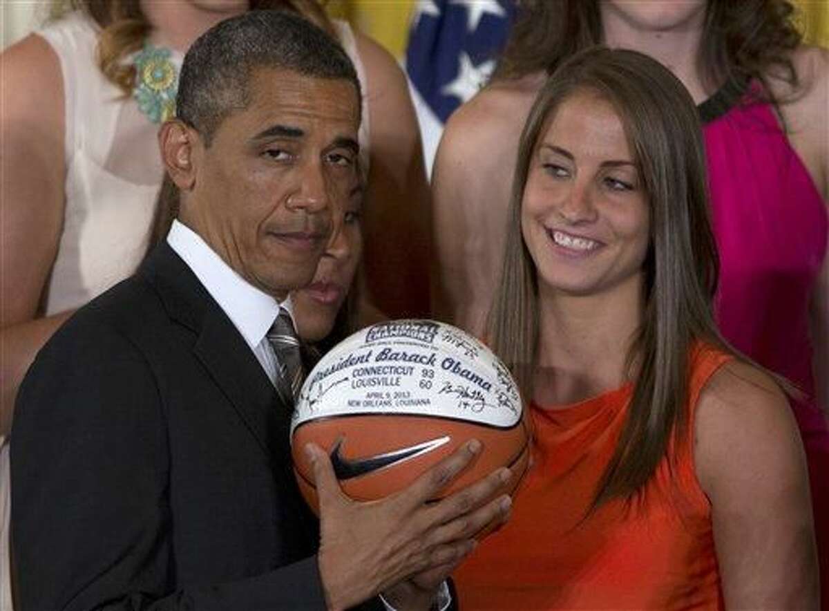 University of Connecticut Huskies basketball guard Caroline Doty looks at President Barack Obama as he shows the signed basketball she just gave him during a ceremony in the East Room of the White House in Washington, Wednesday, July 31, 2013, where the president honored the 2013 NCAA Women's Basketball Champion team, the University of Connecticut Huskies. (AP Photo/Carolyn Kaster)