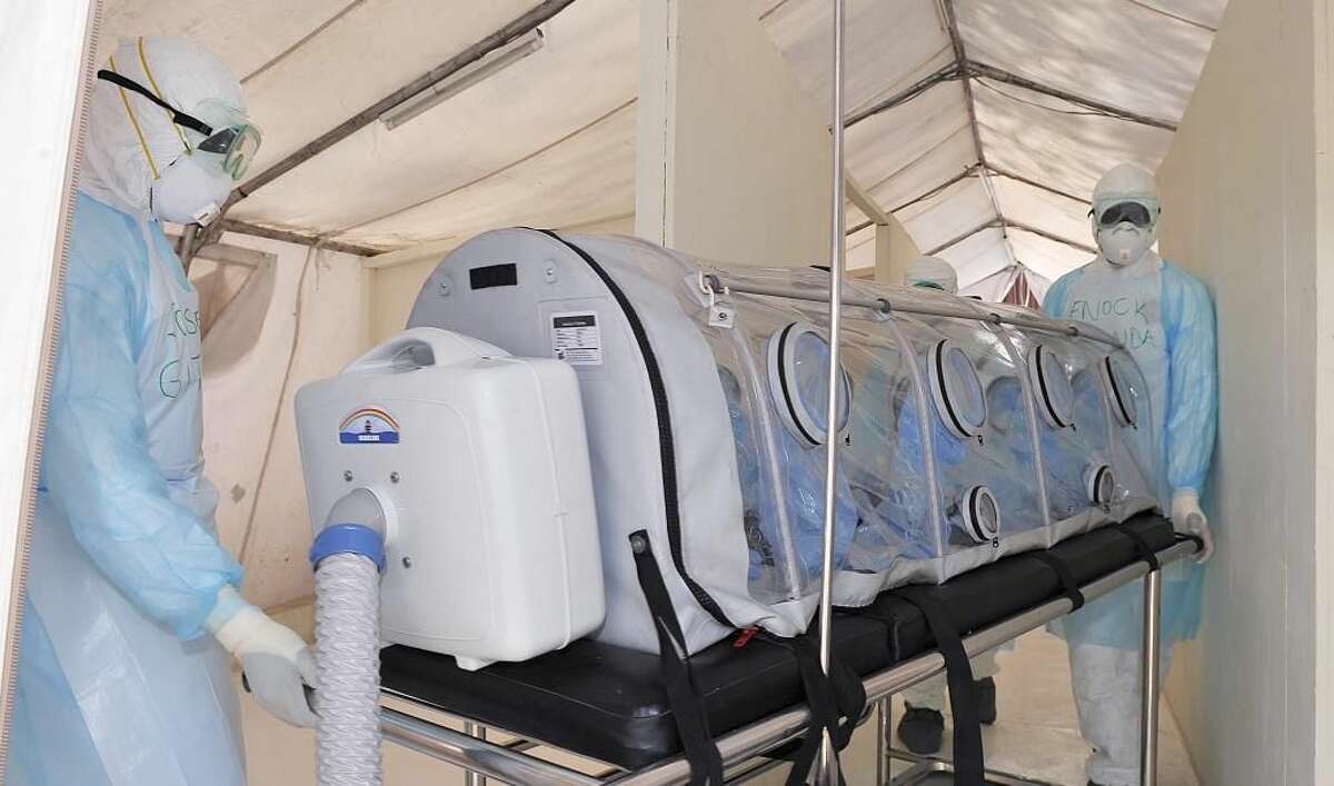 Kenyan medical worker from the Infection Prevention and Control unit wearing full protective equipment show on October 28, 2014, how to handle an infected Ebola patient on a portable negative pressure bed at the Kenyatta national hospital in Nairobi. Measures have been put in place ahead of the arrival of the 12 Kenyans returning from Ebola-hit Liberia. Health officials battling the Ebola outbreak that has killed more than 4,500 people in West Africa have managed to limit its spread on the continent to five countries, with Kenya so far escaping the virus.