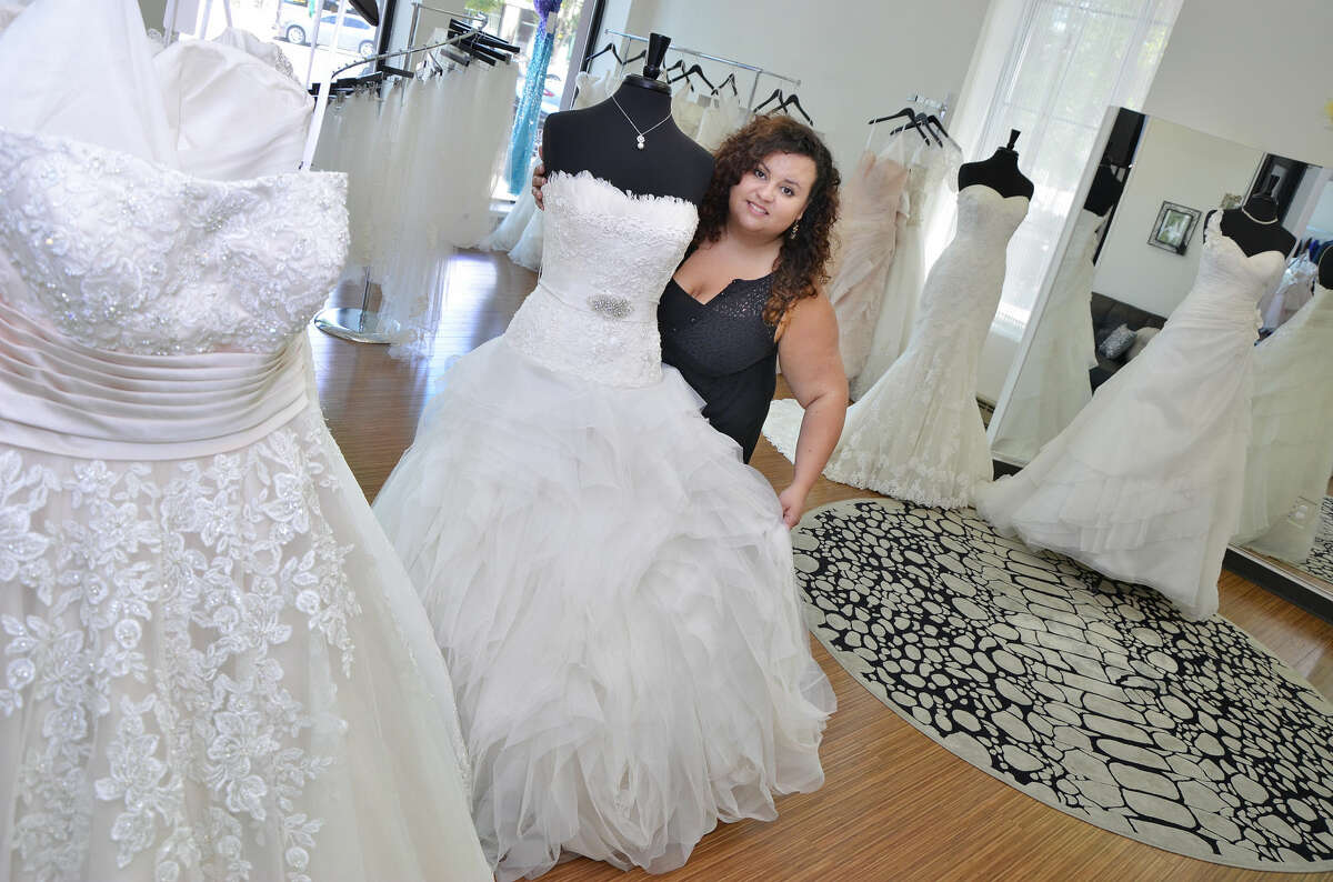 Krista Lastrina Matthews, owner of Lastrina Girls in Middletown, shows off one of the salon's wedding dresses.