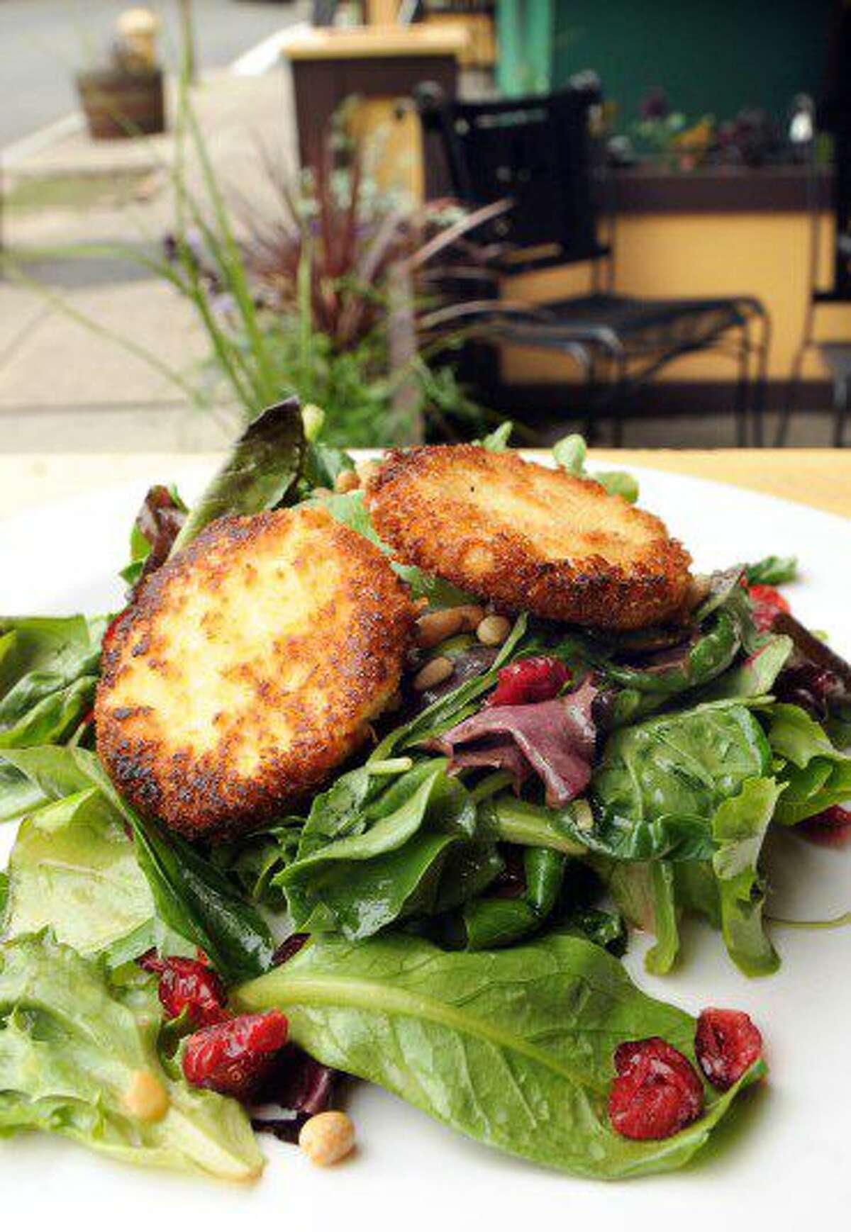 Vermont goat cheese salad: sauteed chevre medallions on baby greens, tossed with a citrus vinaigrette, dried cranberries and pine nuts.
