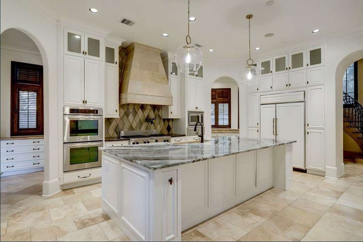 The kitchen has travertine floors and a stone counter.
