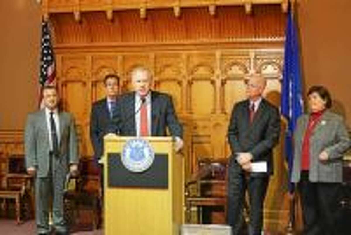 Attorney General George Jepsen speaks at a Capitol press conference flanked at left by Consumer Protection Commissioner Jonathan Harris, Gov. Dannel P. Malloy, and state Comptroller Kevin Lembo. DAS Commissioner Melody Currey is at right.