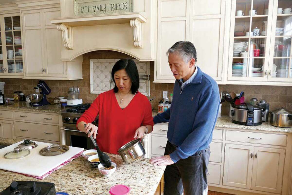 Jeanette Chen and her husband, Michael Chen, go over soup options in their New Canaan kitchen.  