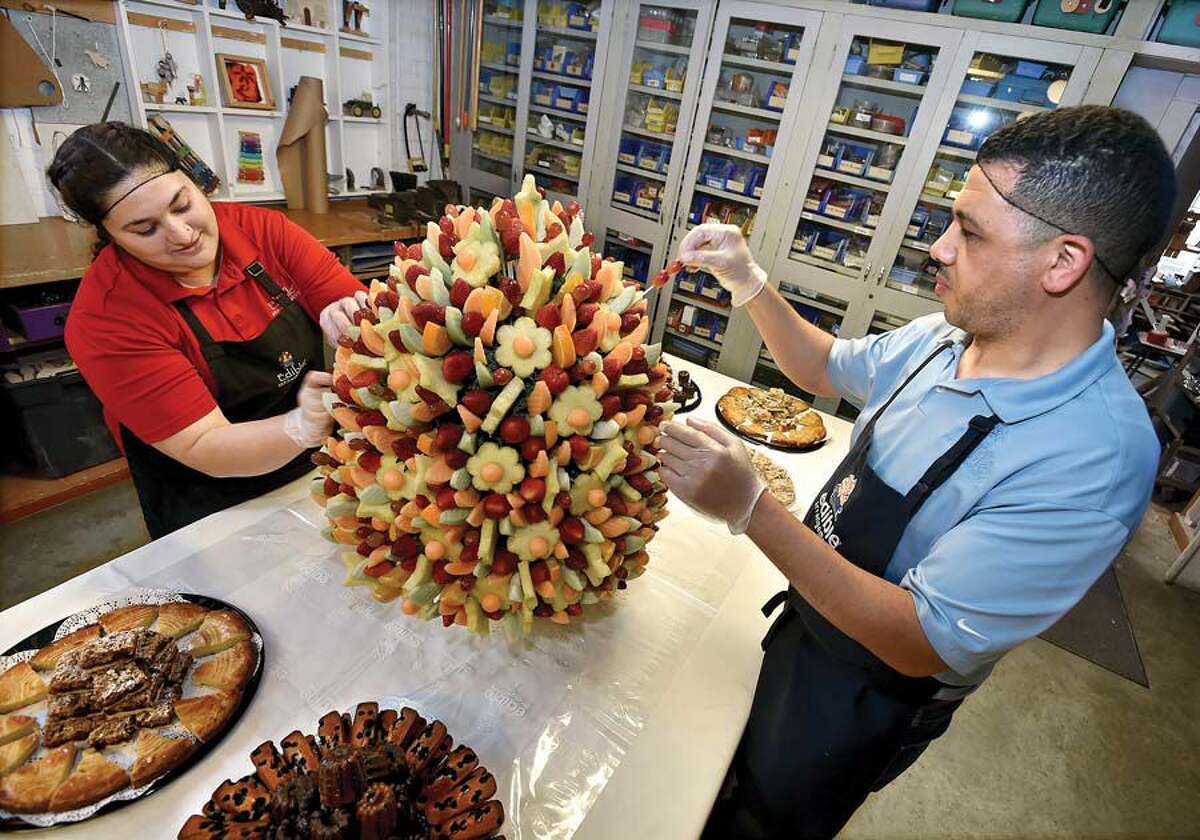 Fouad Elgoute, right, owner of Hamden Edible Arrangements, and store manager Saba Shanawar put the finishing touches on a 3-foot-tall, 65-pound arrangement at the Eli Whitney Museum’s 23rd annual Leonardo in Bloom Challenge fundraiser.