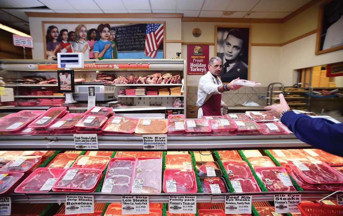 John Peters helps a customer in the meat department at Ferraro's Market.