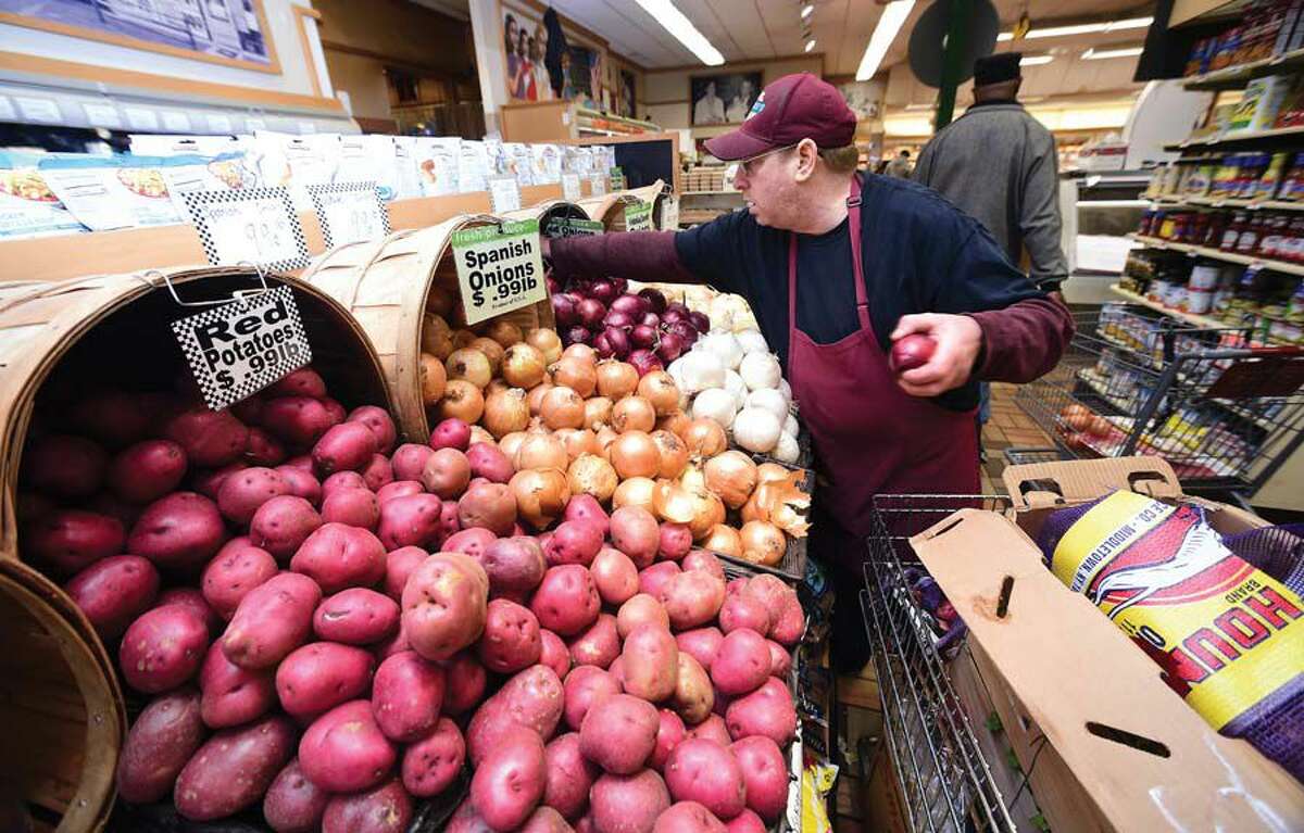 Alan Unger stocks onions in the produce department at Ferraro's Market.