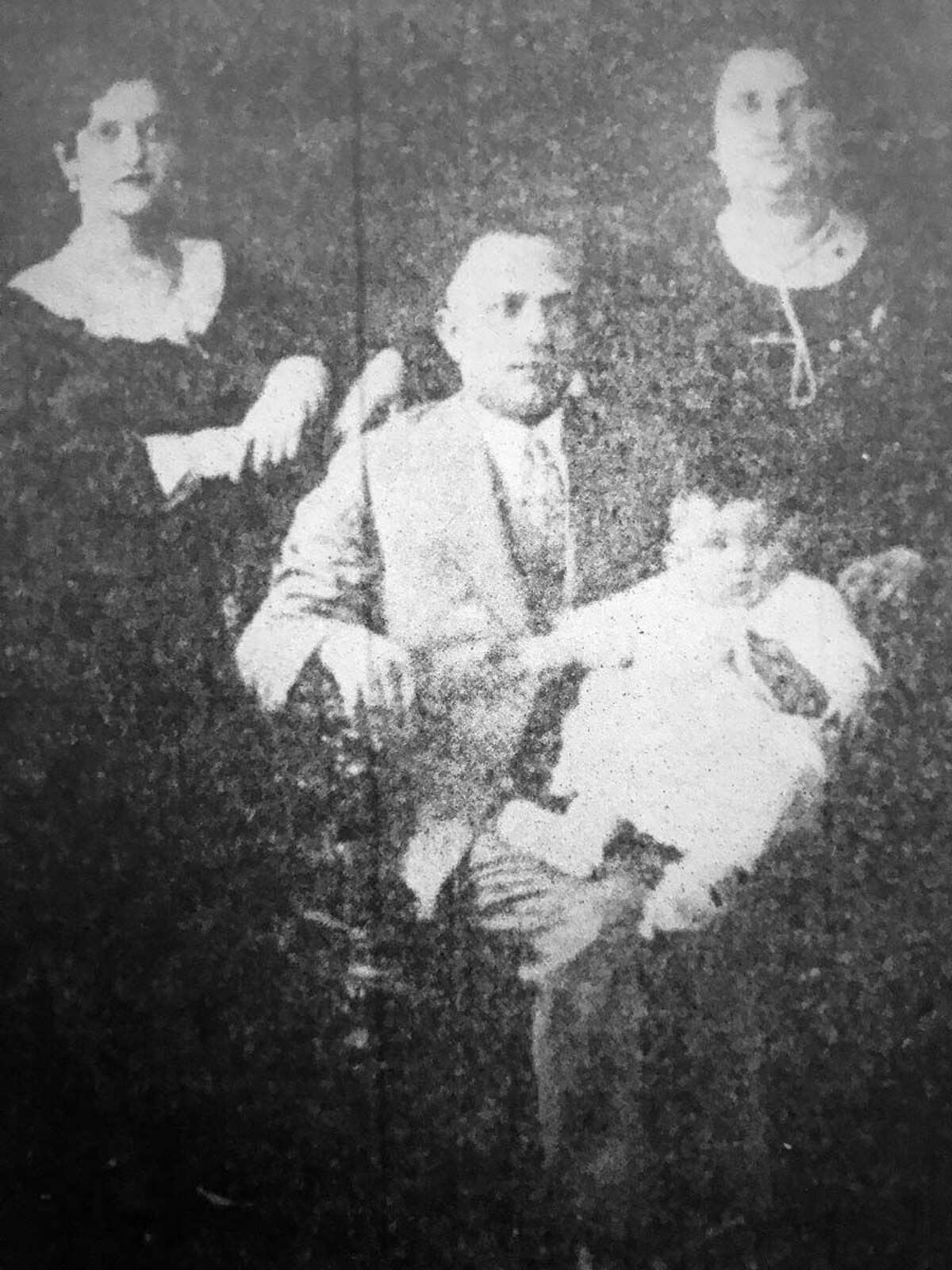 Goldie Tischler (standing at right) hired workmen to replace the Ridge Avenue home’s windows in 1926. The family could never have dreamed what was secreted in the walls. Her husband, Samuel, is seated with baby Maurice on his lap. Their daughter, Rose, is standing at left. 