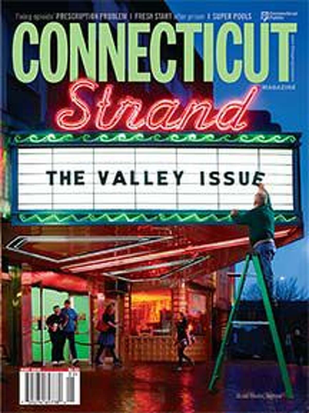 John Fanotto, who manages the Strand Theater in Seymour, puts the finishing touch on this month's magazine cover.