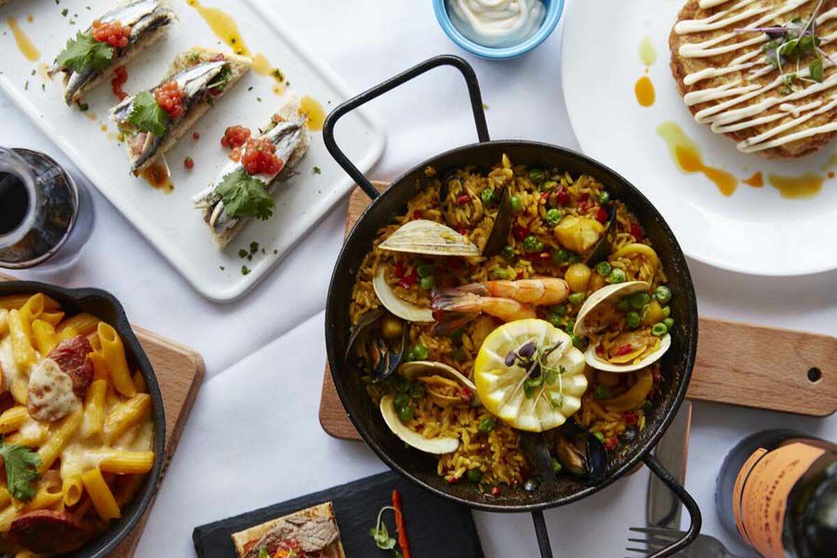 Some of the dishes at Gaudí Tapas and Wine include paella (center), macarrons al forn (bottom left), pincho de boquerones (top left) and tortilla Española (top right).