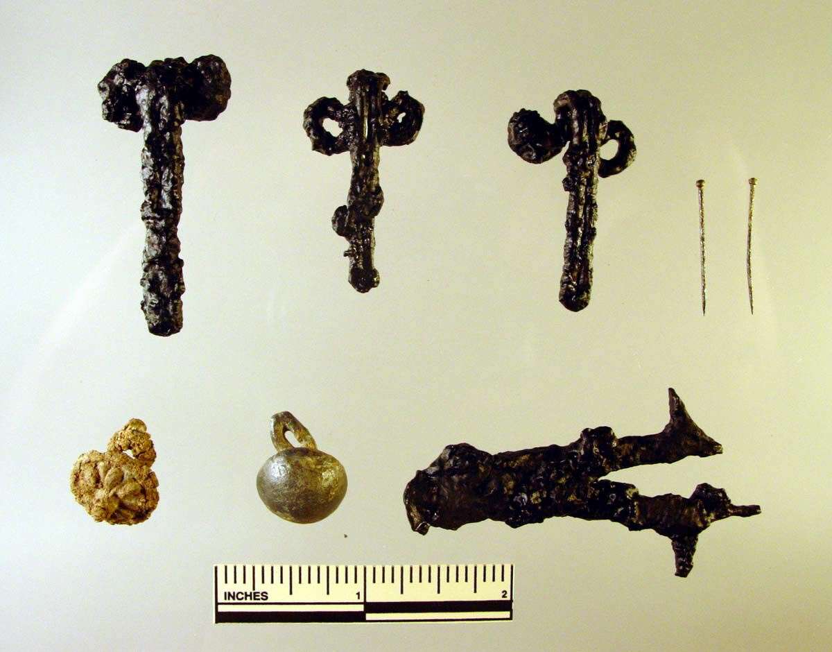 Sampling of objects found during the two-year dig in Wethersfield: iron clothing hooks, straight pins, two buttons, and a fragment of a pair of embroidery scissors.