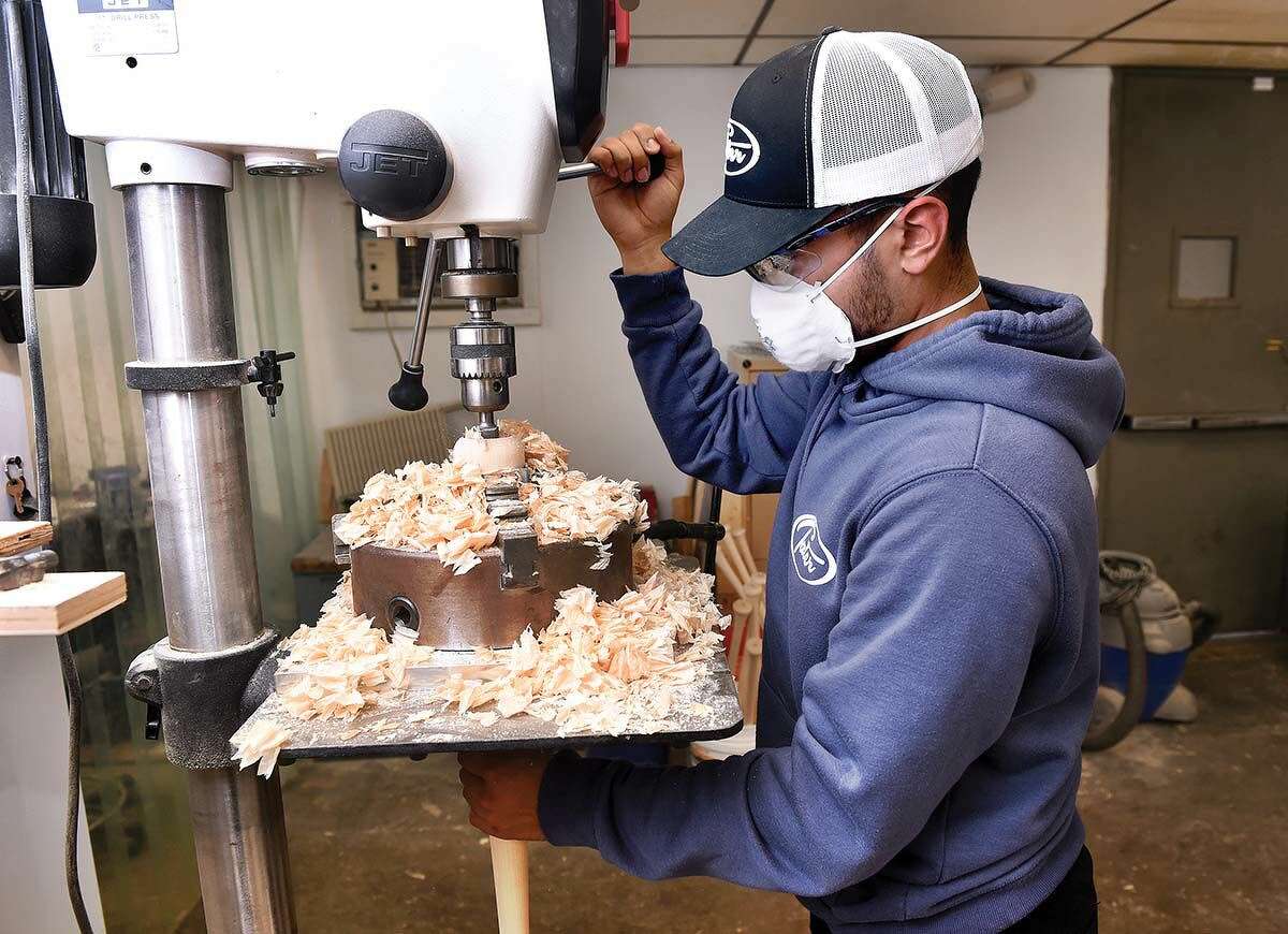 Jeremiah Vargas, co-founder of Tater Bats, cuts a cup in the top of a bat.