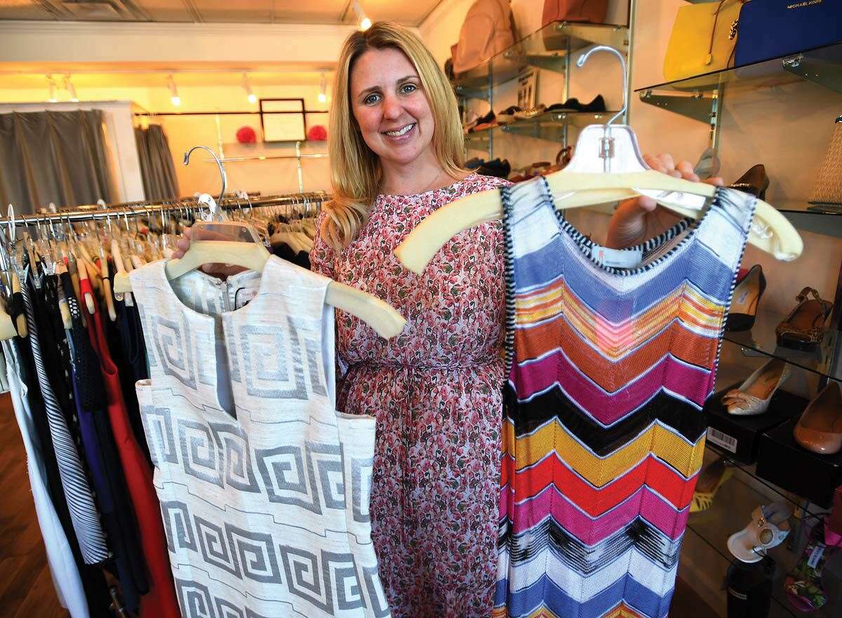 Nicole Yannieh, owner of The Label Exchange in Fairfield, holds designer dresses by Tory Burch and Missoni.