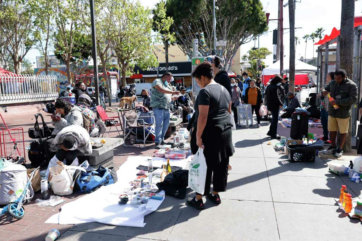 Street vendors and customers crowd the sidewalk around the 24th St. Mission BART Station on March 24.