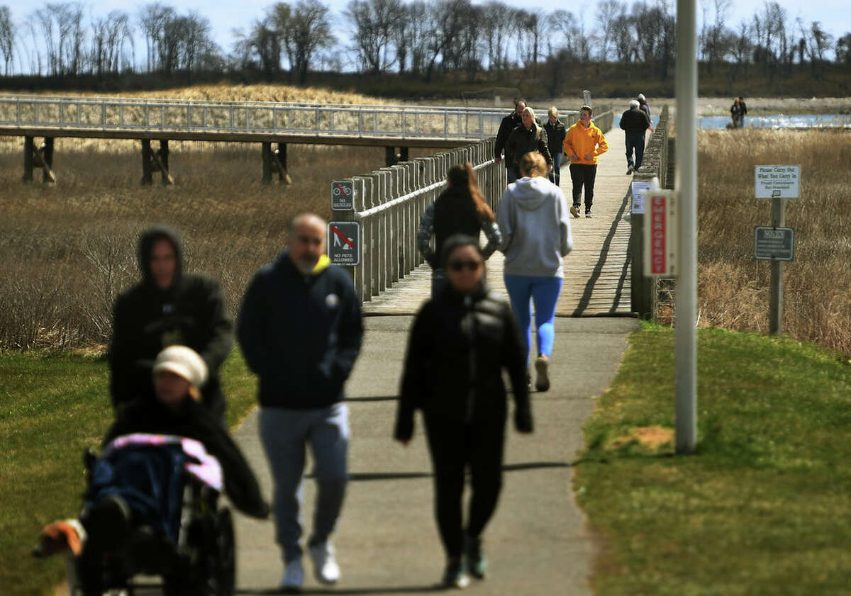 Visitors enjoy a sunny afternoon at Silver Sands State Park in Milford, Conn. on Wednesday, April 1, 2020. The Department of Energy and Environmental Protection announced plans to reduce capacity at popular parks to ensure social distancing in the wake of the coronavirus.