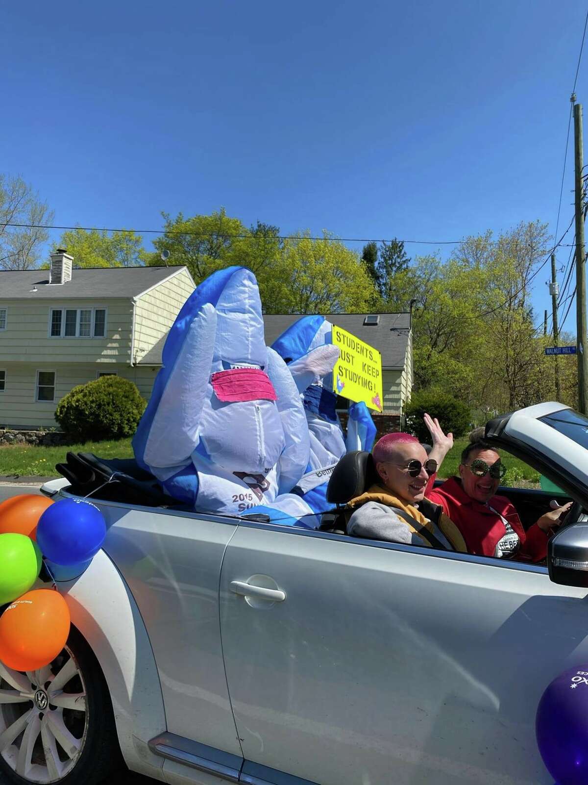 Amanda Riley, director of Bethel school system food services, drives her daughter Emie Riley and two Bethel sharks in a parade to celebrated Teacher Appreciation Day. About 180 staff members drove in multiple convoys across Bethel with school buses, police cars and fire trucks accompanying them. Tuesday, April 5, 2020, in Bethel, Conn.
