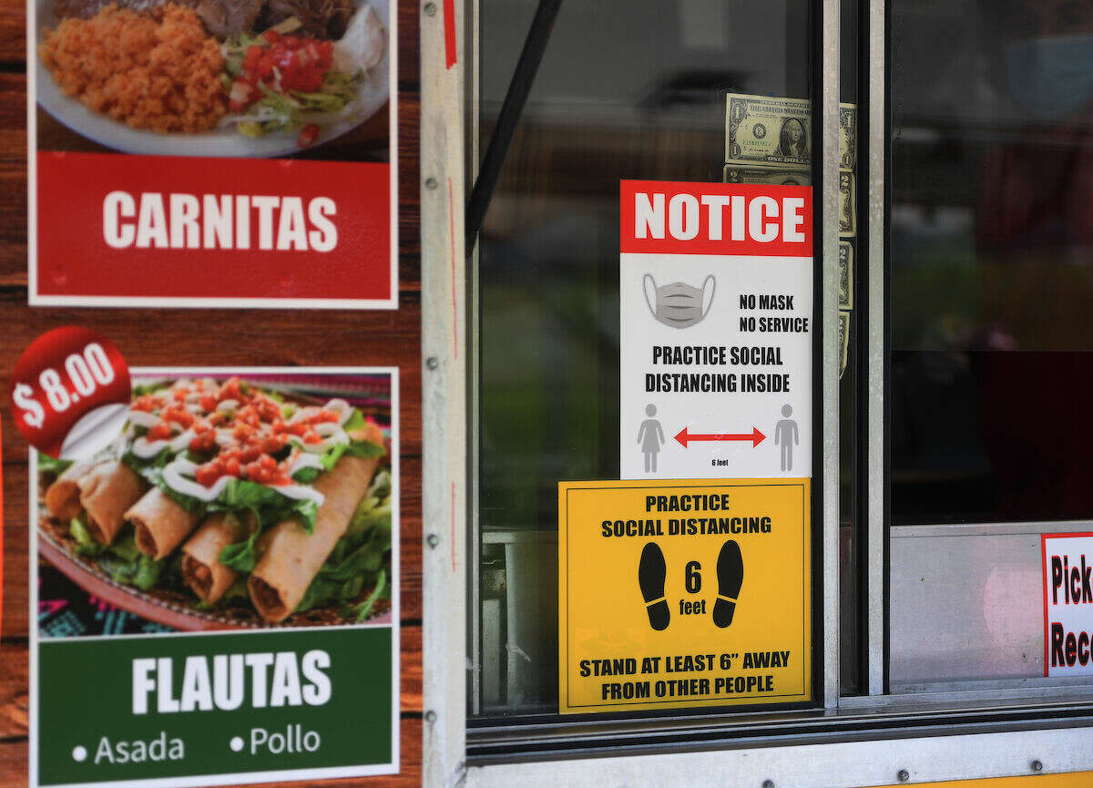 Signs alert customers to mask wearing and social distancing requirements at food trucks at Long Wharf in New Haven, Conn. on Tuesday, May 26, 2020.