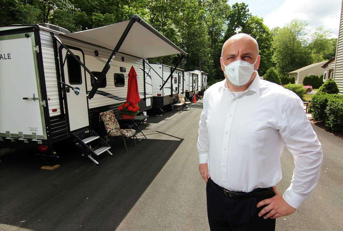 Tyson Belanger, who owns Shady Oaks Assisted Living, poses with some of the trailers he brought in for staff to live in at the facility in Bristol, Conn., on Thursday June 18, 2020. In March as the coronavirus spread through the state Belanger established a bubble at his facility, paying staff at great personal expense to stay full time at the residency.