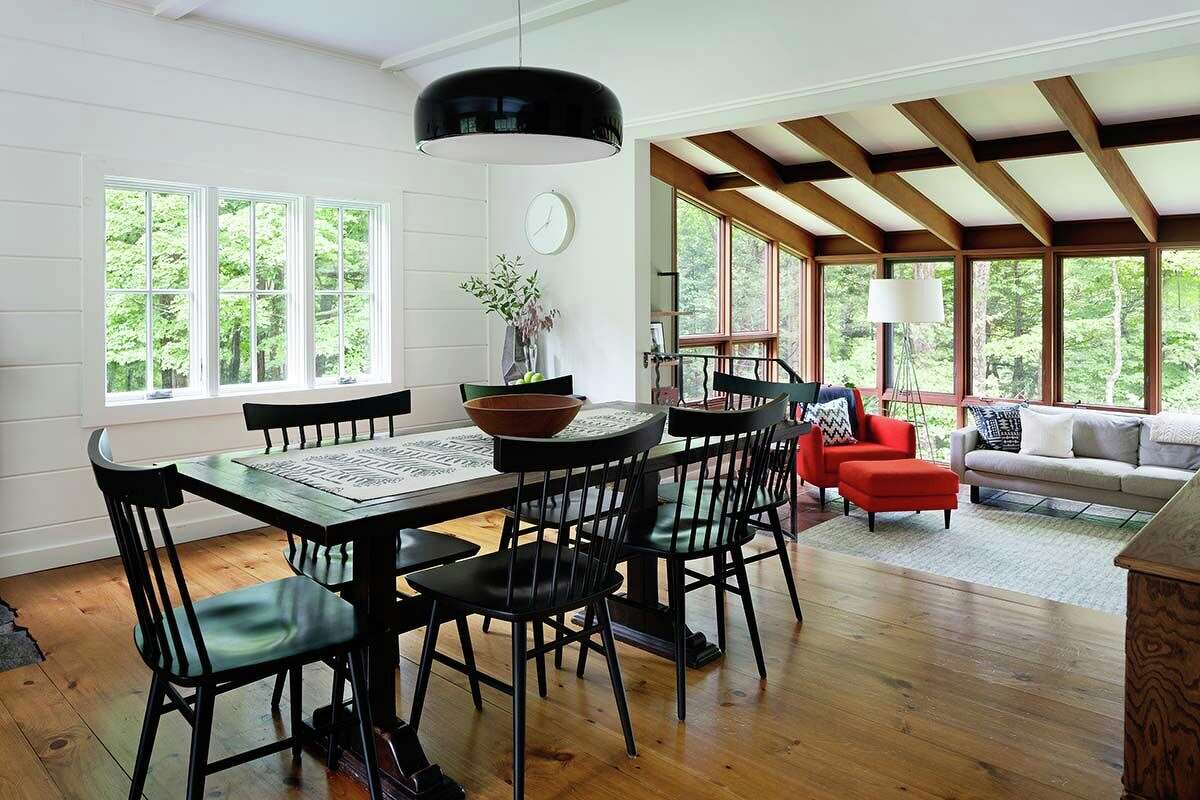 “The dining space marries old and new, pairing a modern pendant light, Flos’ Smithfield S, with classic black spindle chairs and a farmhouse table,” Porter says. “From this space, one can peer into the tree canopy from the living-room windows; the array of windows creates a mural-like effect that changes throughout the seasons.”