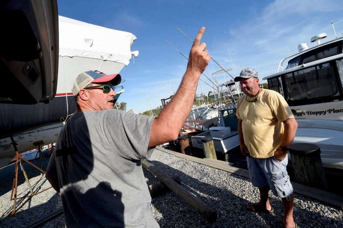 Kevin Barosso, left, of Westbrook and Chris Hales of Waterbury talk about the yacht Lady May at Harry’s Marina in Westbrook on Aug. 20, 2020. President Donald Trump’s former campaign strategist, Steve Bannon, was arrested on federal charges earlier in the day from that yacht off the coast of Westbrook.