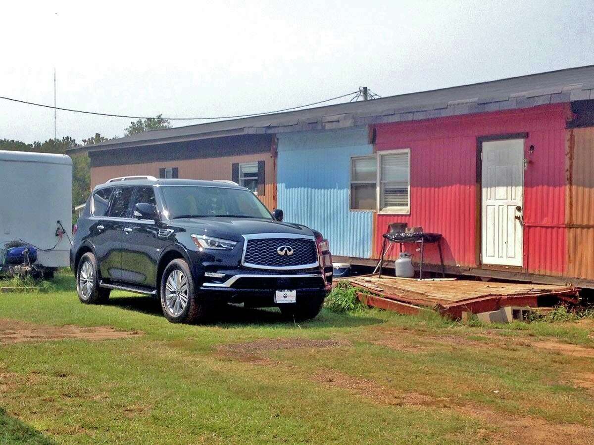 An Infiniti SUV is parked outside a dilapidated mobile home (note the front steps/porch and repaired siding) off Route 818 in Ruston, Louisiana.