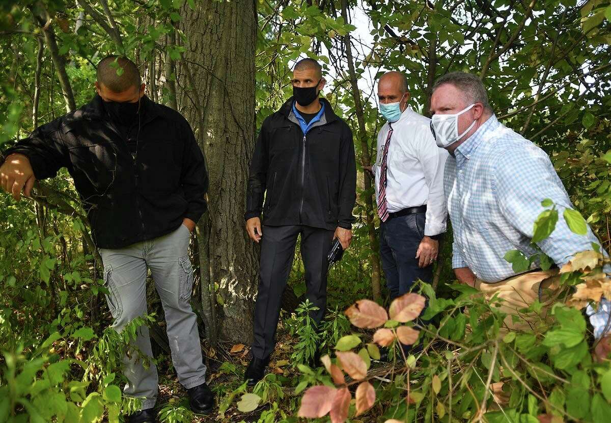 Members of the Hartford Police Department — from left, Sgts. Mike Rykowski and Anthony Rykowski, and Cold Case Unit Dets. Andrew Jacobson and Kevin Salkeld — near where Sylvia Baker’s body was found in Hartford’s Keney Park in 1982.