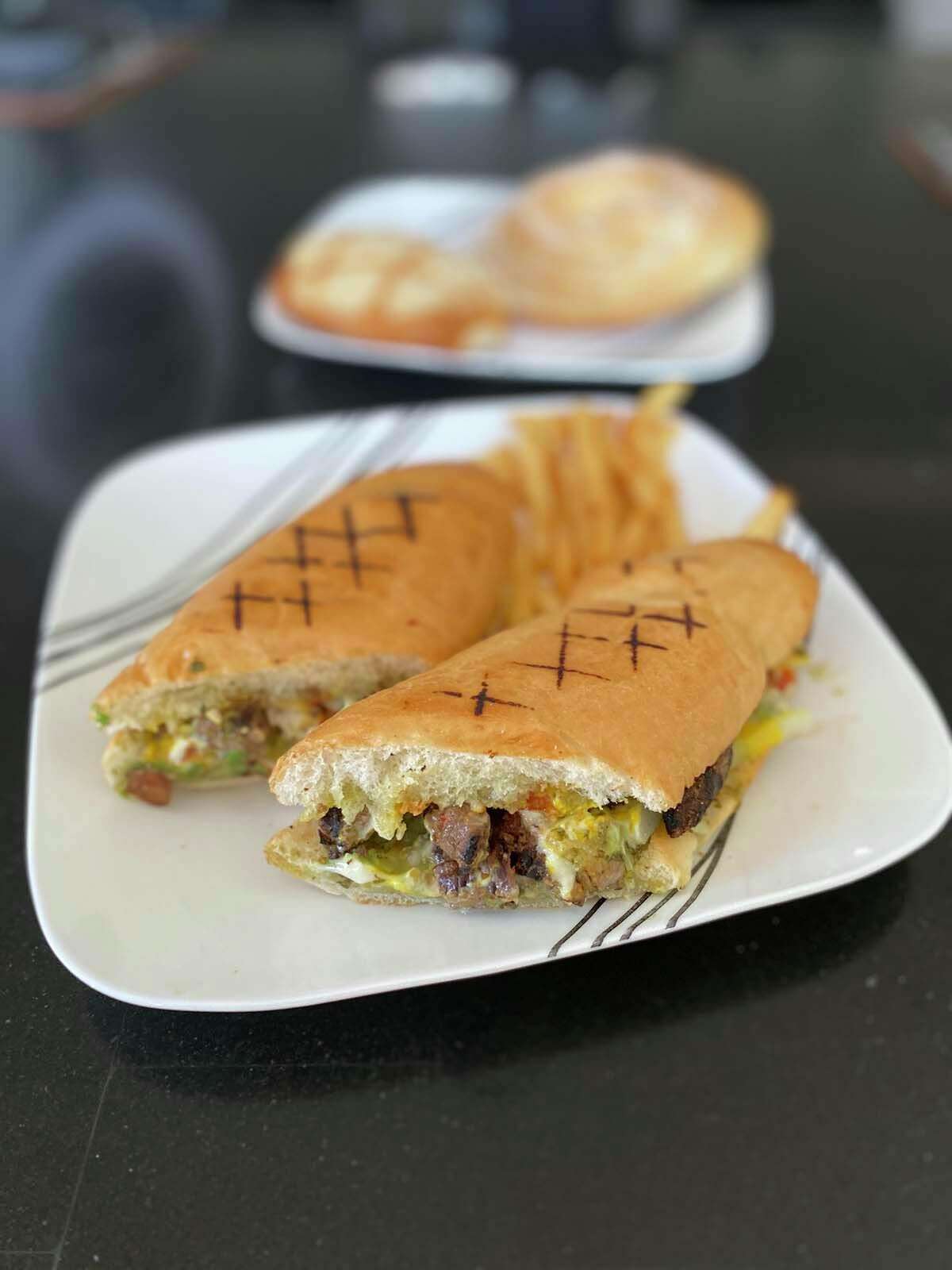 Shucos, or Guatemalan “hot dogs,” are served on freshly baked sub rolls with carne asada, grilled chicken or chorizo, along with chimichurri, avocado, cabbage salad, ketchup, mayo and mustard.