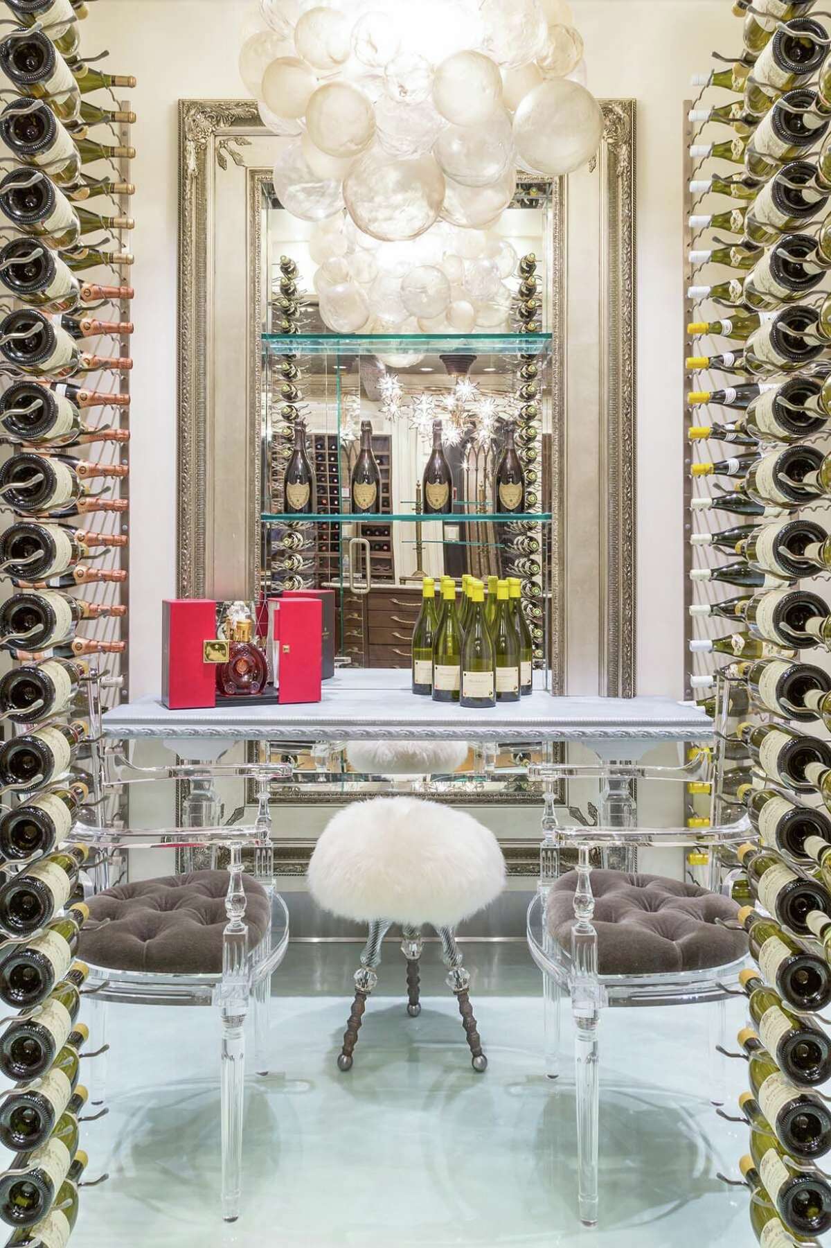 Summit Wine Cellars partnered with Kellie Burke Interiors to fabricate this sparkling wine cellar design in West Hartford. Glass, metal wine racks, and bubble chandeliers work to make this a festive wine storage solution.