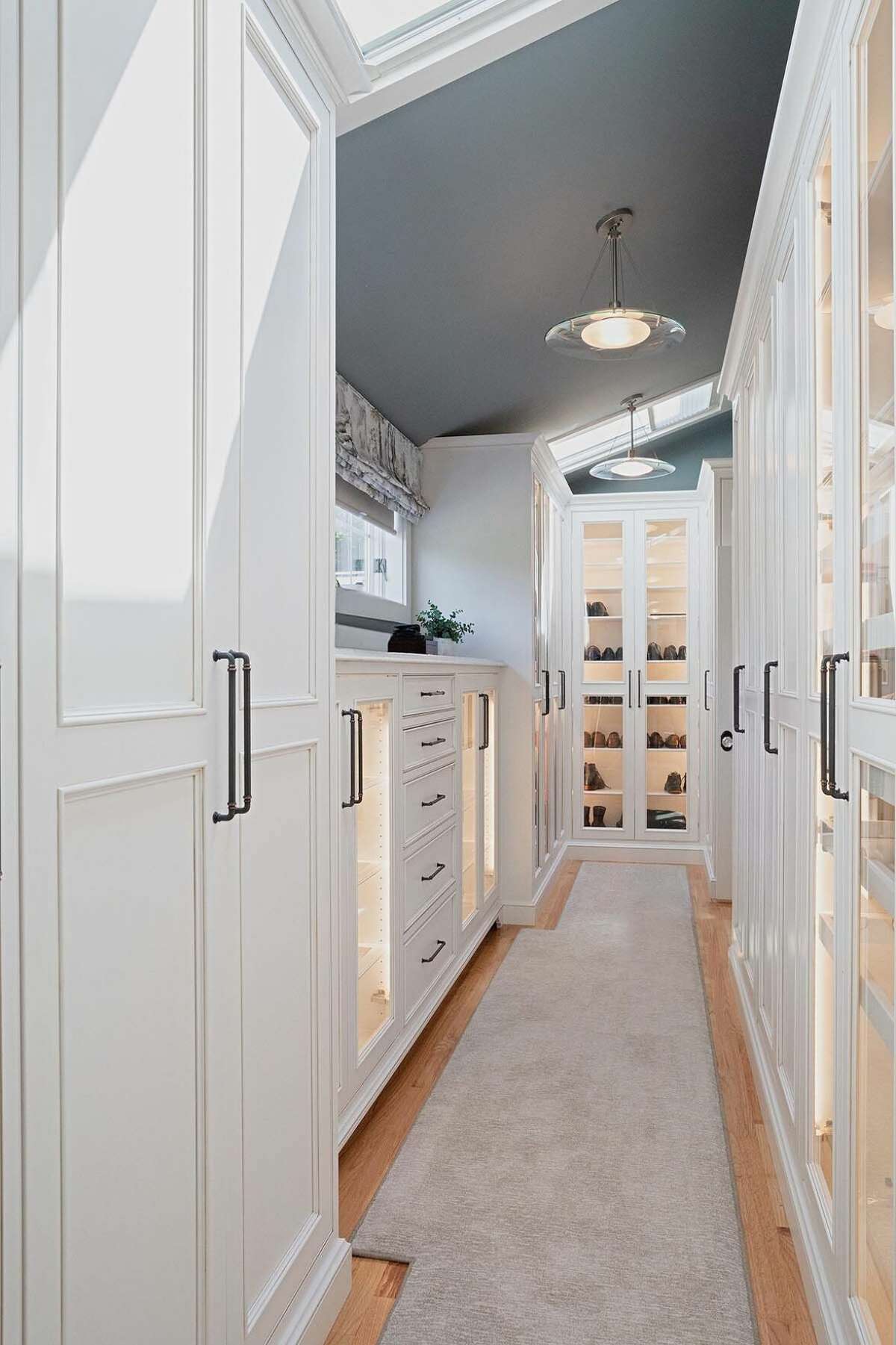Substantial structural changes went into expanding the master closet. Lighting behind glass cabinet doors makes it easy to find the perfect outfit or pair of shoes, while skylights add natural light.