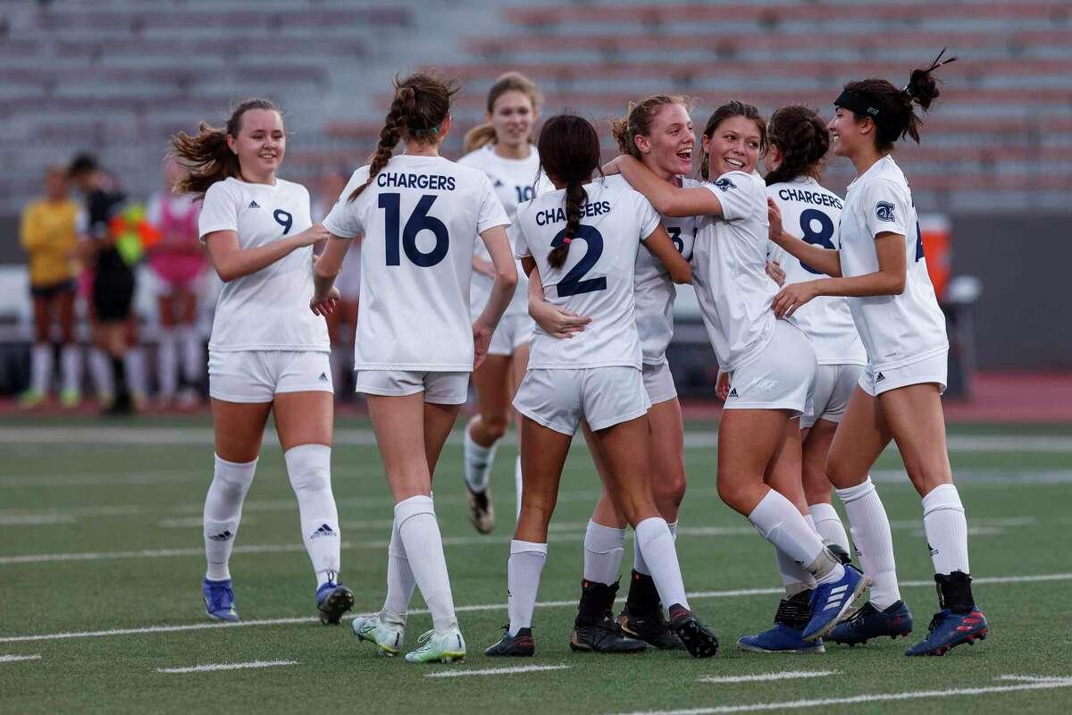 Boerne-Champion's Regan Alt (13), center, is embraced by teammates as they celebrate her goal against the Jefferson Mustangs during a Class 5A playoff game at Alamo Stadium in San Antonio, Texas, Tuesday, March 29, 2022. The Boerne-Champion Chargers defeated the Jefferson Mustangs 10-0.