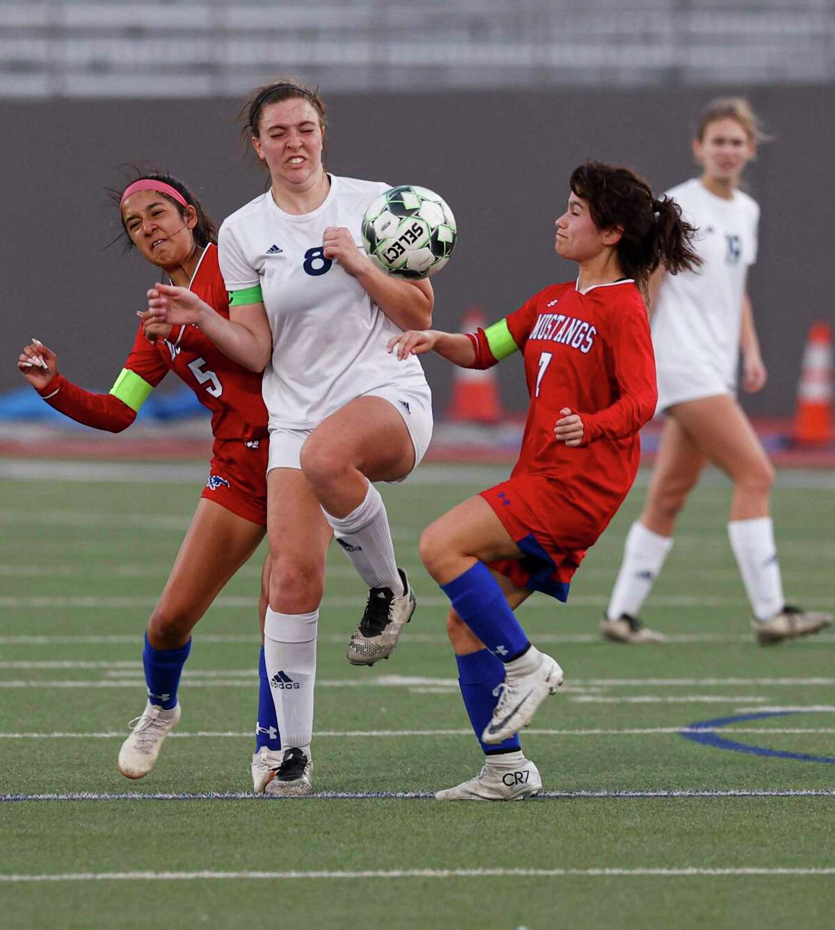 Jefferson's Arianna Solis (5), Boerne-Champion's Skyleigh Arnold (8) and Jefferson's Jaslyn Orozco (7) fight for the ball during a Class 5A playoff game at Alamo Stadium in San Antonio, Texas, Tuesday, March 29, 2022. The Boerne-Champion Chargers defeated the Jefferson Mustangs 10-0.