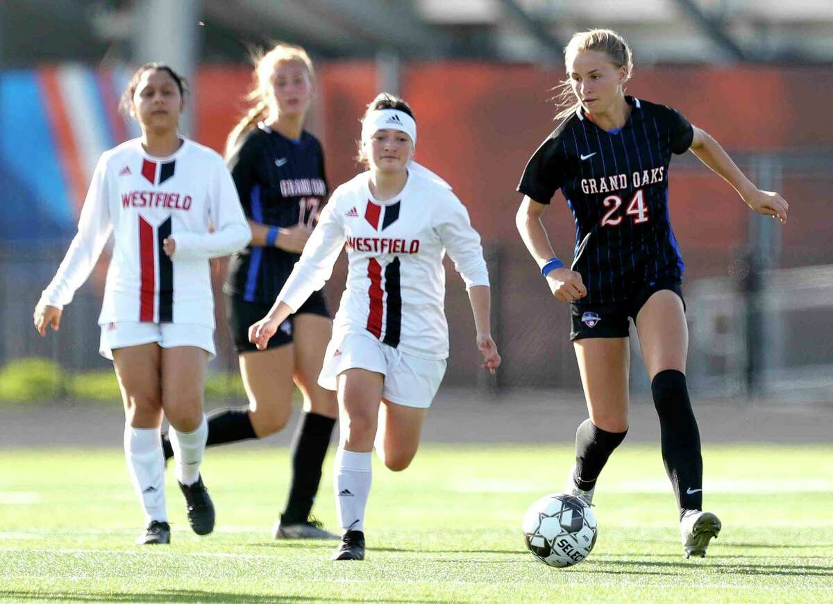 Grand Oaks' Maddie Bruegger (24) dribbles the ball during the first period of a Region II-6A bi-district high school soccer match at Grand Oak High School, Friday, March 25, 2022, in Spring.