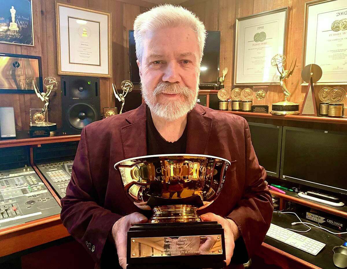 The composer poses with one of his many career awards.