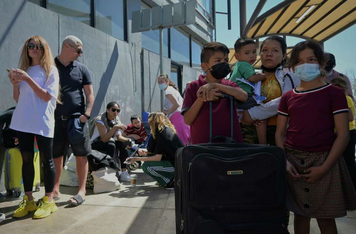 A woman and her children from Mexico wait at the San Ysidro port of entry alongside Ukrainian refugees last Thursday. The single mother, who said she and her children were fleeing a home of abuse, were not allowed to cross into the U.S. and pursue asylum.