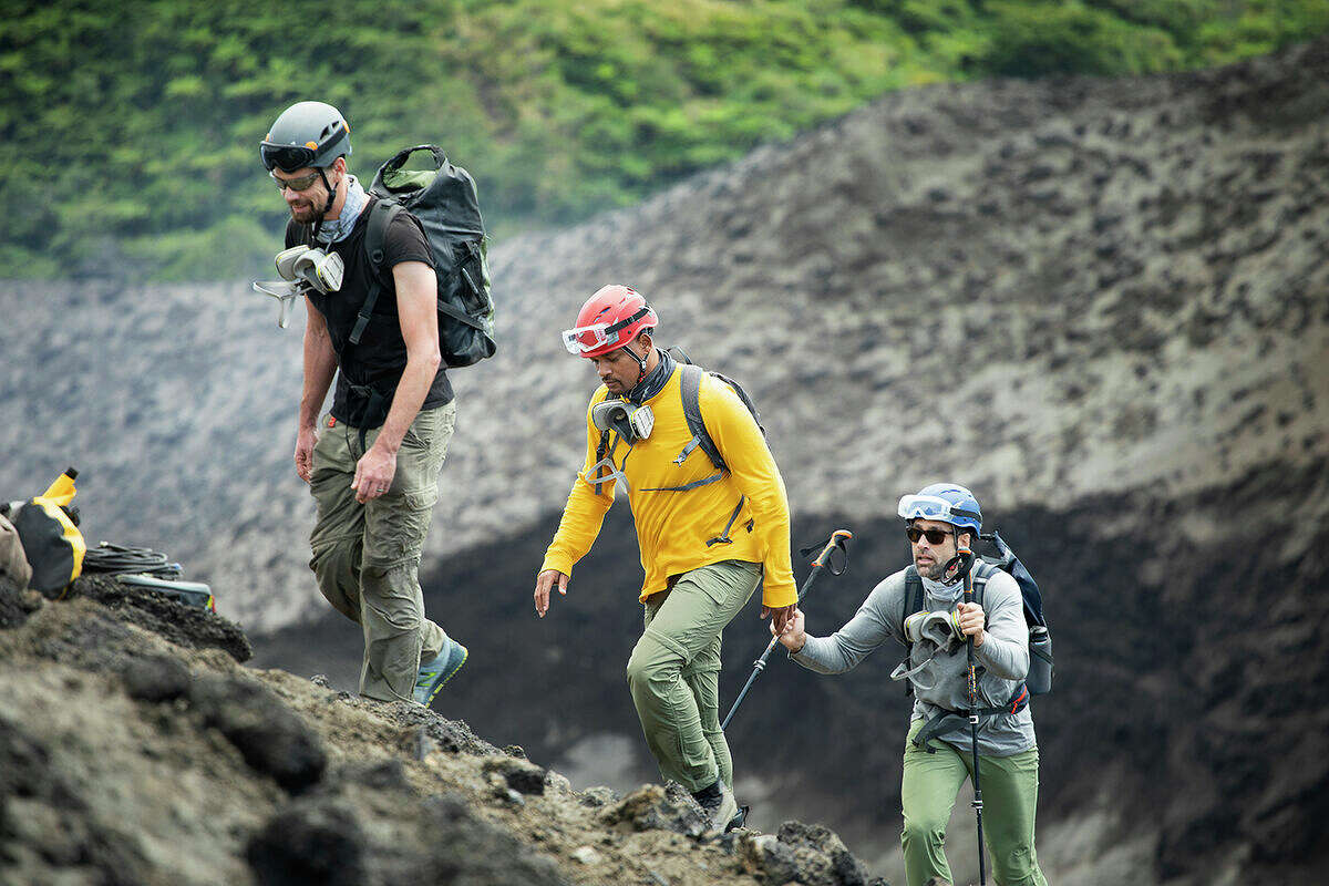 From left, vulcanologist Jeff Johnson, Will Smith and Erik Weihenmayer prepare to descend into the Mount Yasur volcano to install sensors.