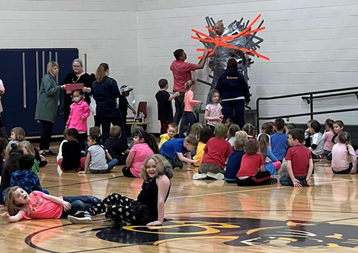 Baldwin Elementary School Principal Bruce Mangum is duct taped to the gymnasium wall as part of a National Reading Month challenge.